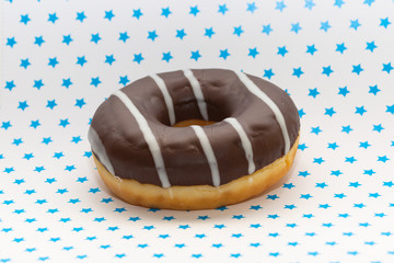 donut on white with blue stars background, close up view
