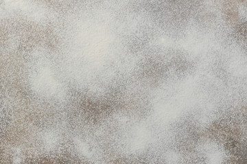 Flour on light brown background, top view