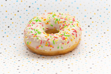 donut on white with colored stars background, close up view