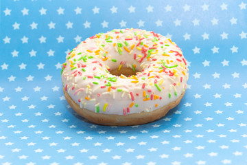 donut on blue with white stars background, close up view