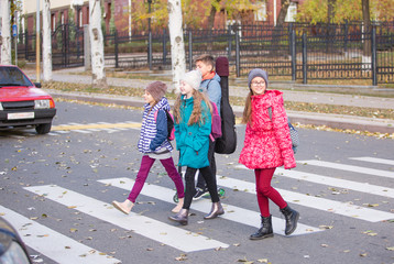 children go to school on the sidewalk with a fun company.