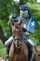 A mounted knight in shining armor readies his lance in preparation for combat in Turku, Finland. 