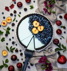 Obraz na płótnie Canvas fresh blueberry tart with fruits on white conrete background