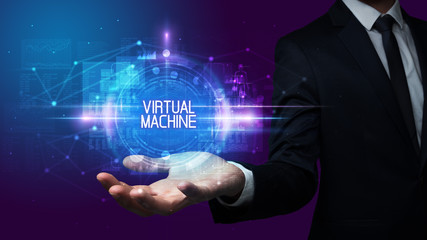 Man hand holding VIRTUAL MACHINE inscription, technology concept
