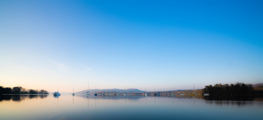 Early morning sunrise light boats on Lake Windermere in the English Lake District, UK