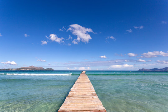 A wooden pier at Playa de Muro beach in Mallorca