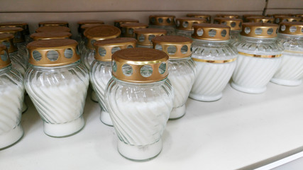 Indoor, outdoor candles in a candle store. Candles for sale in interior decorating store. Variety of different candles in shop. Discounts and sales. Large white candles in a gift shop.