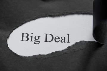 Word BIG DEAL printed on a white background with black torn paper.