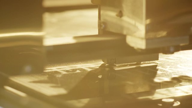 Macro view of automated carving machine working and engraving letters and patterns on surface of dark granite block dedicated for memorial stones or headstone.