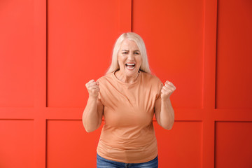 Angry mature woman on color background