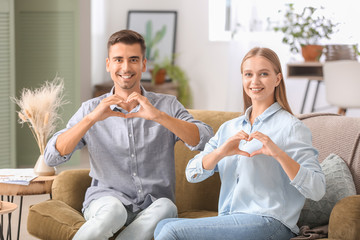 Young deaf mute couple using sign language at home