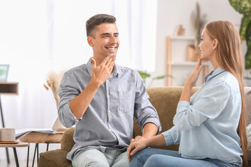 Young deaf mute couple using sign language at home