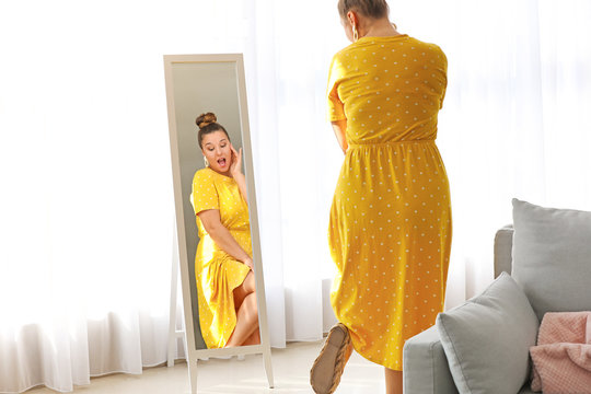 Young Body Positive Woman Looking In Mirror At Home