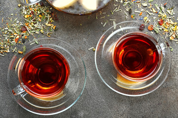 Cups of hot tea on grey background