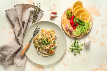 Plate with tasty pasta, cheese and vegetables on table