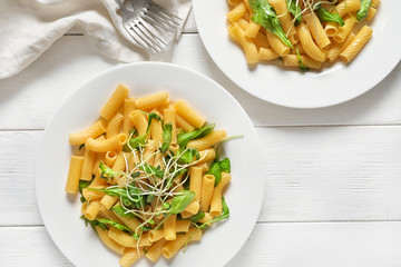 Plates with tasty pasta on table
