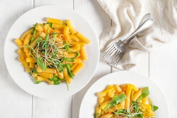 Plates with tasty pasta on table