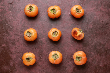 Ripe persimmons on color background