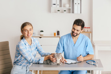 Obraz premium Woman with her cat visiting veterinarian in clinic