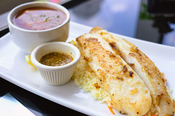 Grilled Pangasius with rice and garlic sauce, serve with mash potato.