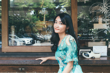 Beautiful Asian woman smiling in outdoor scene.