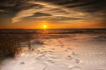 Beach ocean, foot prints on the white sand and sunset sky landscape
