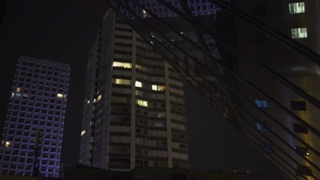 Under Black Skyscraper reflection with glass windows at business district in Paris at night, slow steadicam movement Tracking Out, Reflections. Futuristic modern building with lights. 4K UHD.