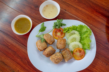 Deep Fried Crab meat roll or Hoi jo with sweet sauce on white plate , thai food, asian food, chinese food.
