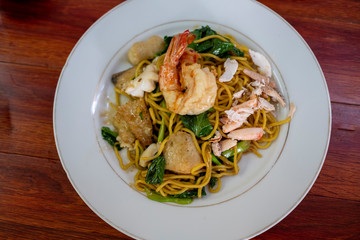 Stired fried yellow noodles with shrimp on white plate , top view, Chinese food, thai food, asian food.