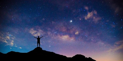 Traveler Man Silhouette Stand Top Mountain.Panorama blue night sky milky way and star on dark...