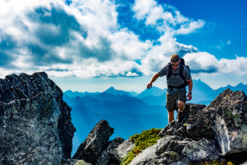 Obraz premium Adventurous man hiking on top of a mountain.