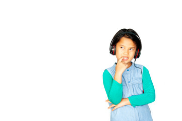 Asian pretty little girl in green shirt listening music in headphones and singing on white...