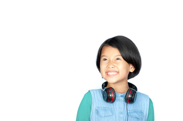 Asian pretty little girl in green shirt listening music in headphones ain hip hop concept on white background. Charming girl in shorts and earphones posting with alot copy space.