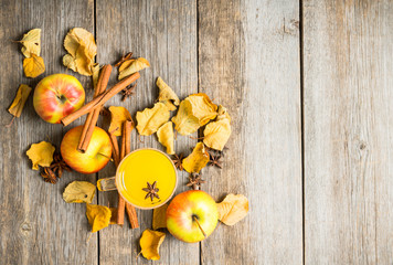 Autumn hot and spicy drink with pumpkin and orange juice on the rustic background. Selective focus. Shallow depth of field.