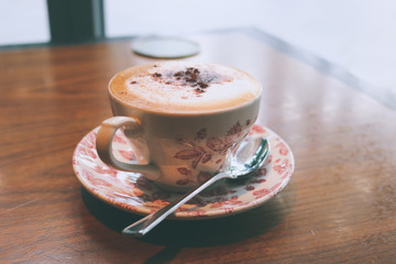 A cup of latte on the table. A latte is a coffee drink made with espresso and steamed milk.