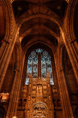 LIVERPOOL, ENGLAND, DECEMBER 27, 2018: Magnificent stained glass from interior of the Church of England Anglican Cathedral of the Diocese of Liverpool with biblical sculptures of jesus christ.