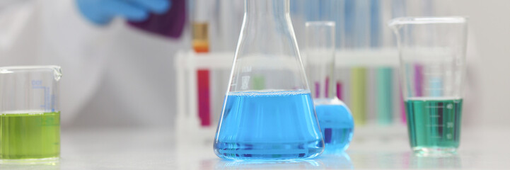 A male chemist holds test tube of glass