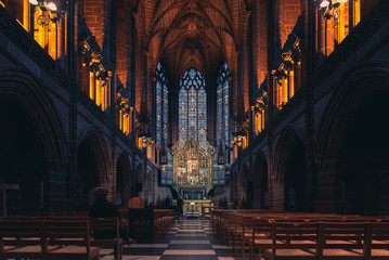 LIVERPOOL, ENGLAND, DECEMBER 27, 2018: The Lady Chapel in Liverpool Anglican Cathedral. Perspective view of a magnificent part inside the church, where light meets darkness all along place. - obrazy, fototapety, plakaty