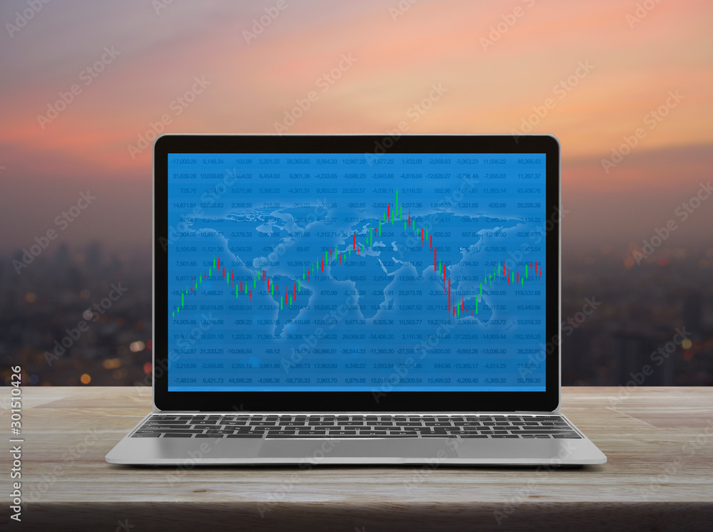 Poster trading graph of stock market with world map and graph on modern laptop computer on wooden table ove