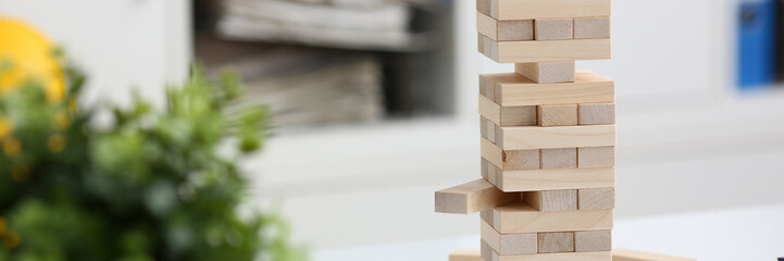 Businessman plays in a strategy of jenga hand