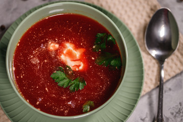 Beetroot borsch with sour cream and a plate in a plate, close-up. Tasty and hearty dinner. Borsch with vegetables