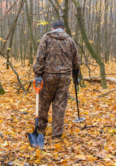Naklejka premium metal detector at work in the forest. Search for treasure and ancient values. Archeology. Man with a metal detector. Minesweeper .selective focus