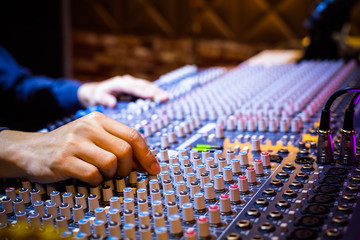 producer, sound engineer hands working on audio mixing console in recording broadcasting studio