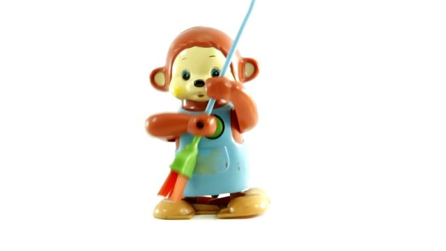 retro toy monkey sweeping up isolated on white 