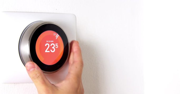 4k Smart Thermostat with a someone warning up the temperature