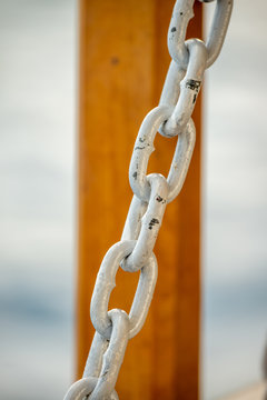 Close up of the links of a rusted white chain