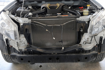 car repair station in over light and during replacing the auto part in a car workshop by an experienced mechanic after an accident