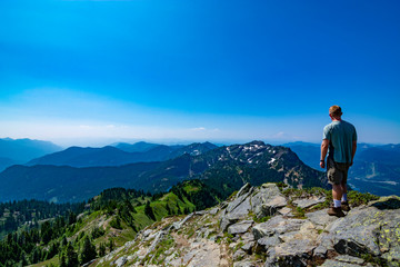 Naklejka premium Adventurous man standing on top of a mountain.
