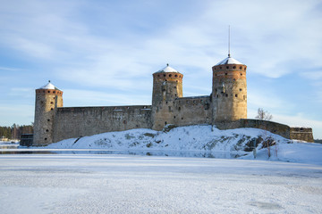 The ancient fortress of Olavinlinna on frozen Saimaa Lake on a winter day. Savonlinna, Finland