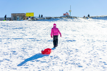 Little girl sledding at Sierra Nevada ski resort.